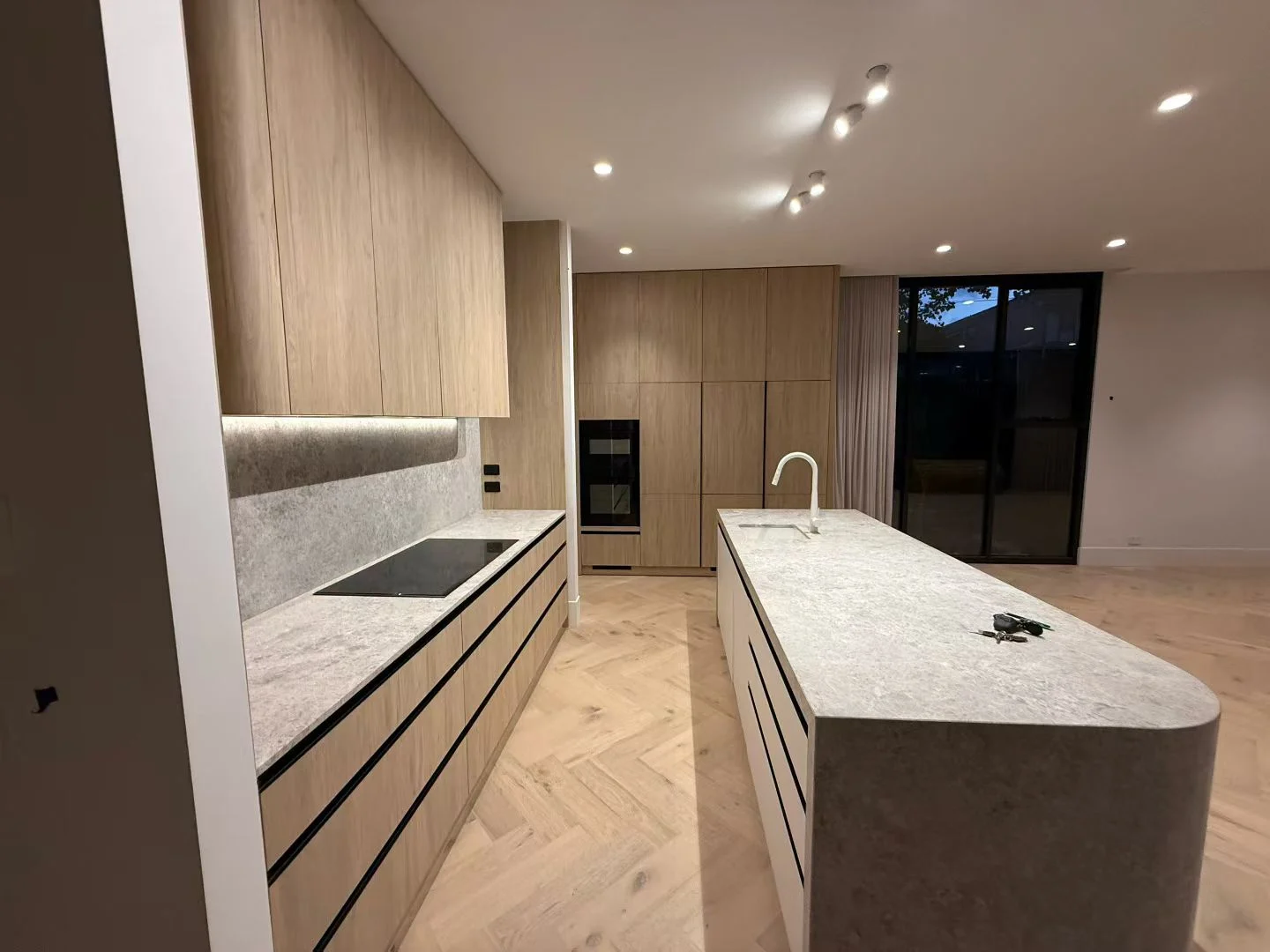 SNEJ project in Australia showing oak kitchen cabinetry and a pale island worktop